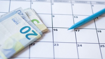 Calendario con soldi e una penna